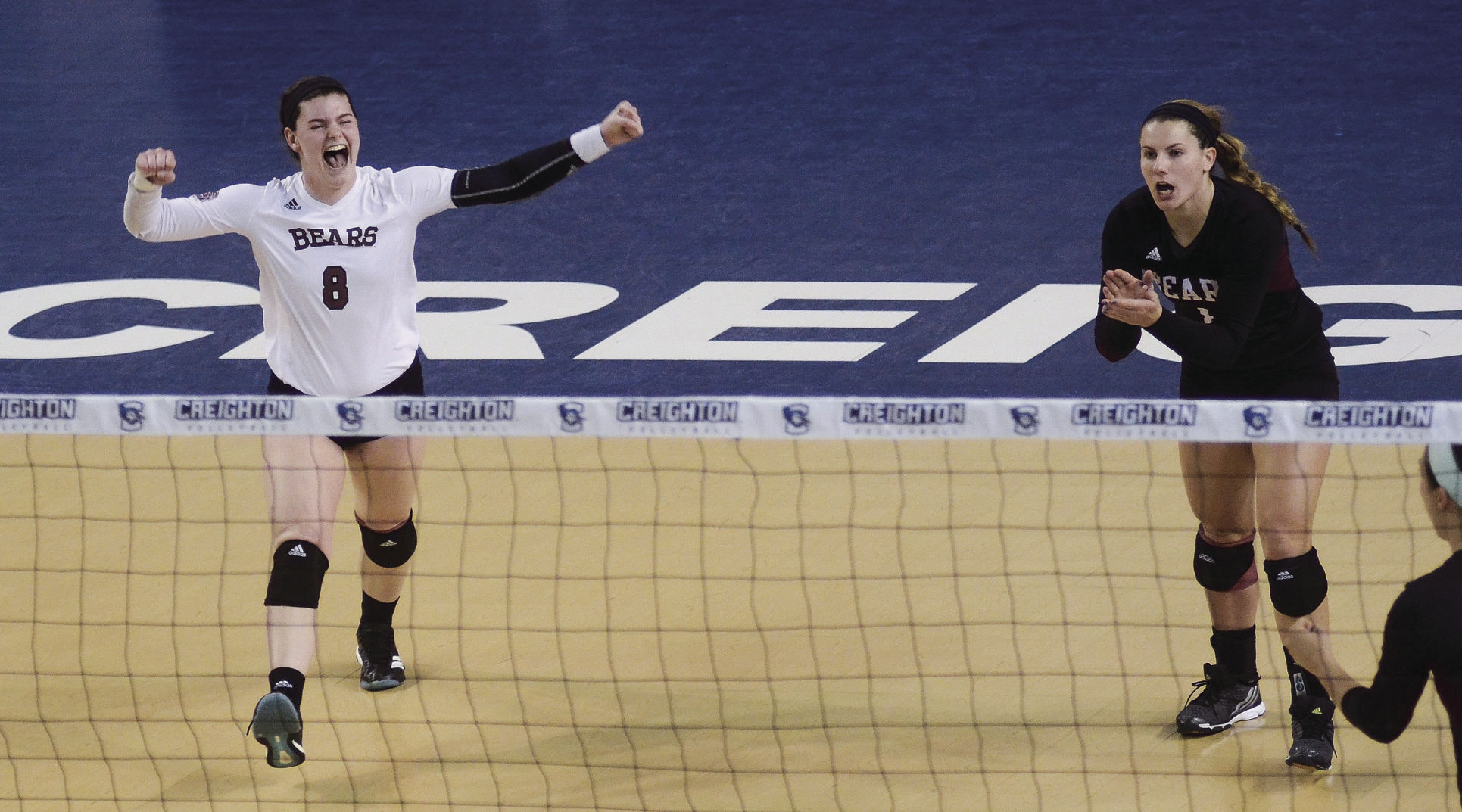 Emily Butters and Brianne Dixon celebrate after senior Lily Johnson's kill